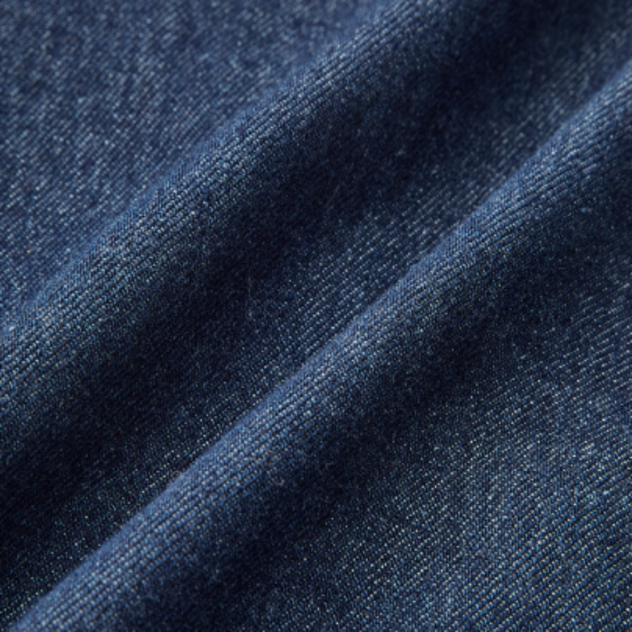 Close-up of dark blue denim fabric on a white background