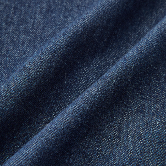 Close-up of dark blue denim fabric on a white background